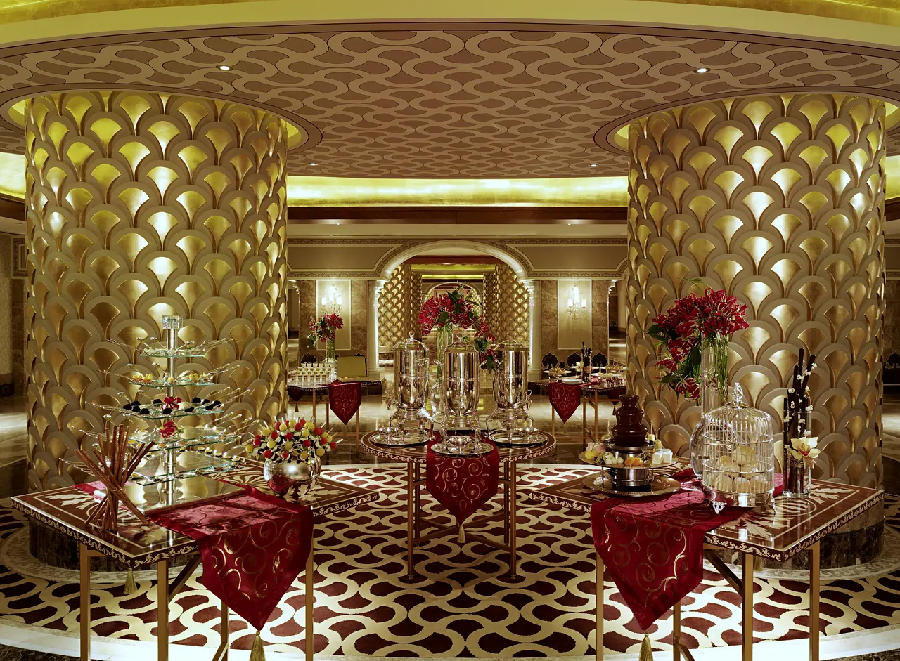 Mardan Palace — Hall with gold scale-patterned columns and set tables