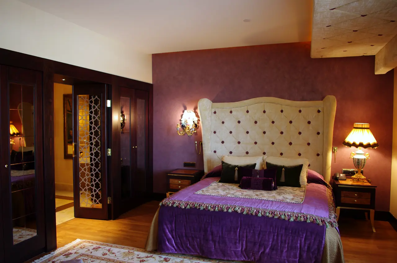 Mardan Palace — Bedroom with tufted headboard and purple cover