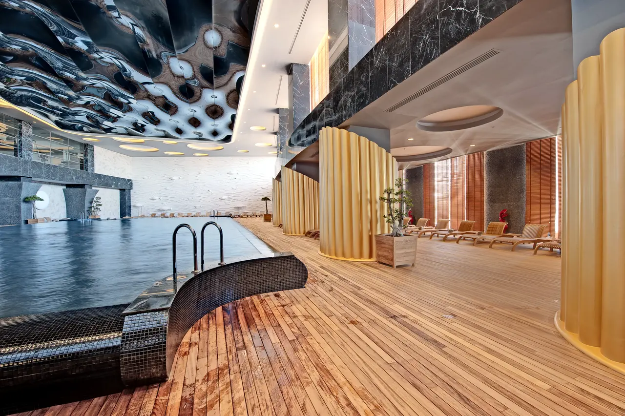 Maxx Royal Belek — Indoor pool with undulating ceiling and wooden deck