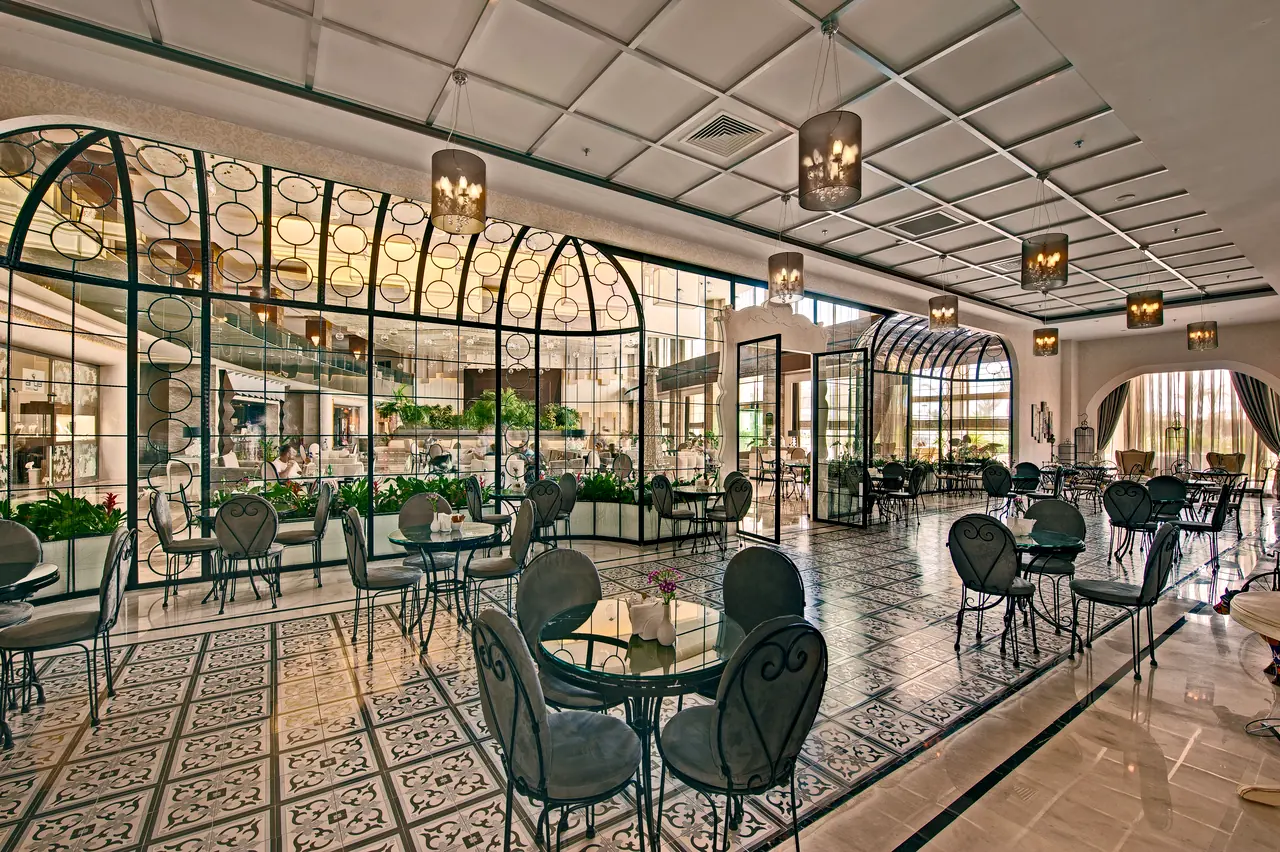 Maxx Royal Belek — Café with birdcage-shaped metal screens and patterned floor