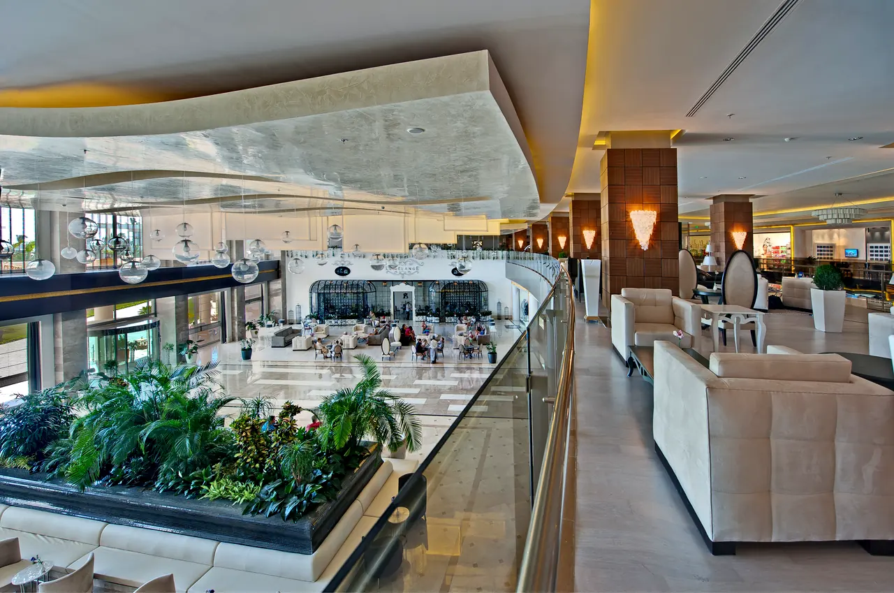 Maxx Royal Belek — Gallery-level seating group beside a planter