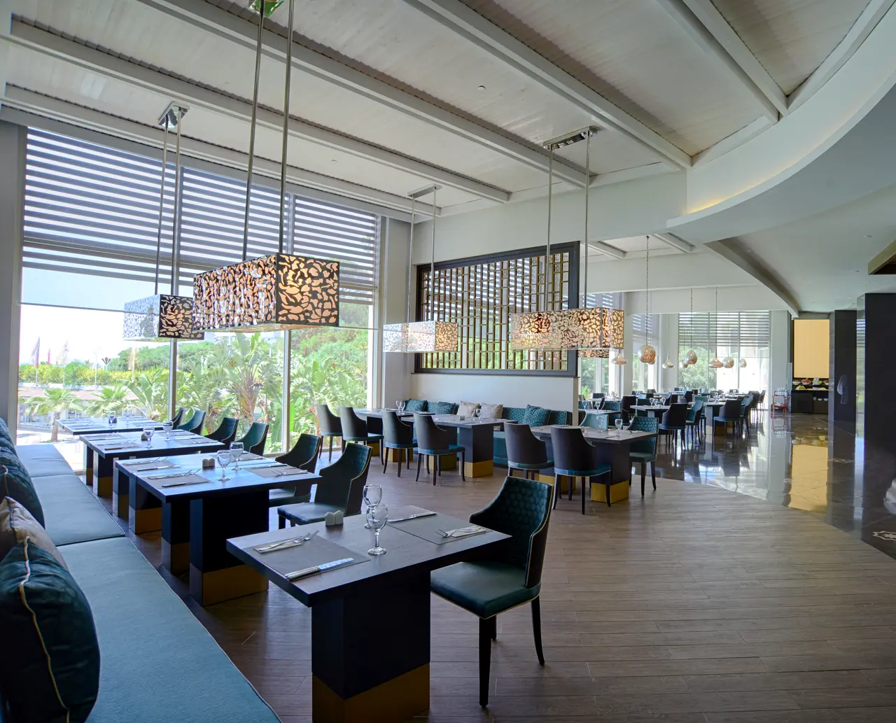 Rixos Premium Belek — Restaurant with long banquette and tables along the windows