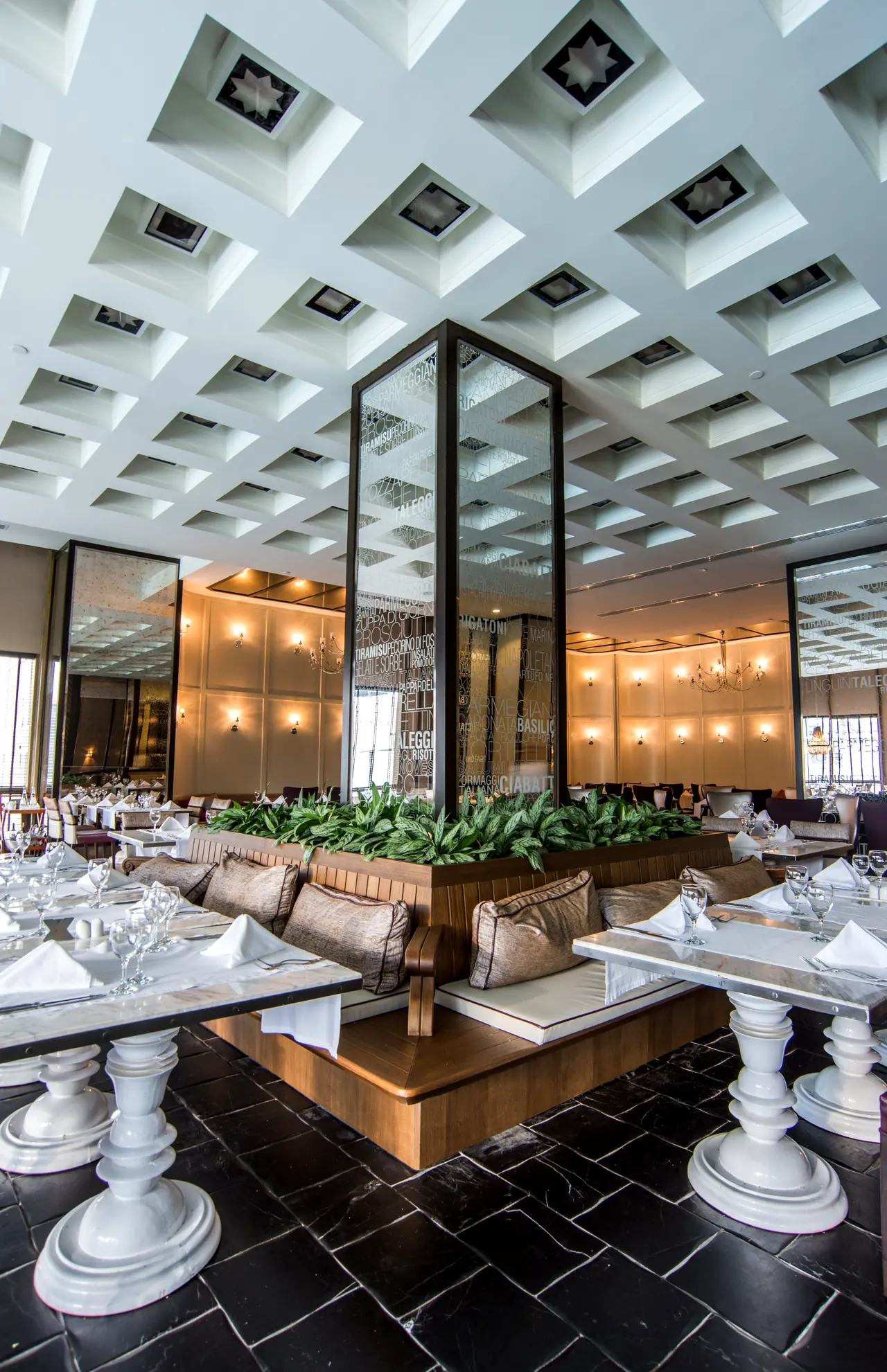 Rixos Premium Belek — Lit partitions and tables beneath a coffered ceiling