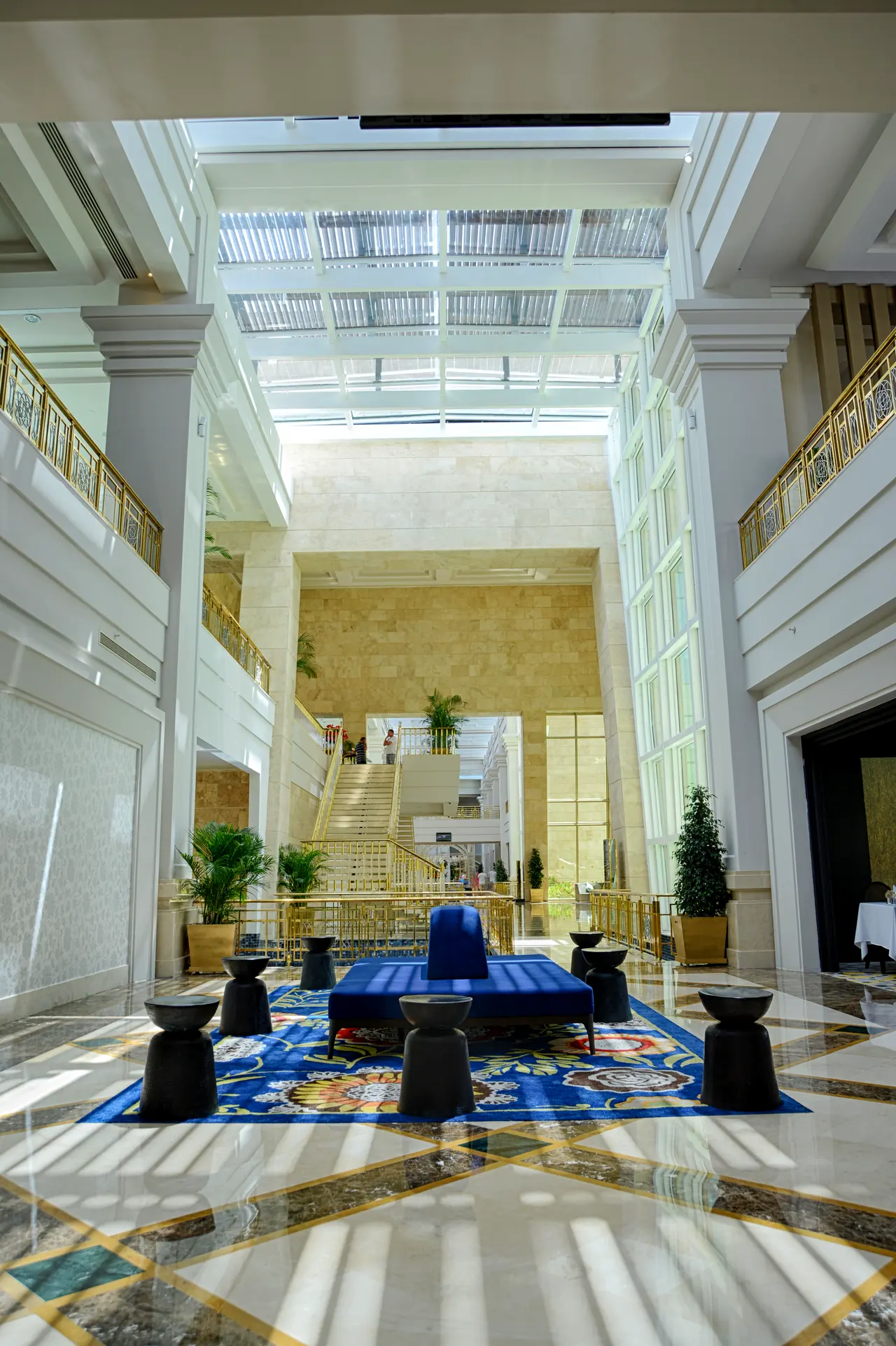 Rixos Premium Belek — Multi-storey lobby with blue rug and seating groups