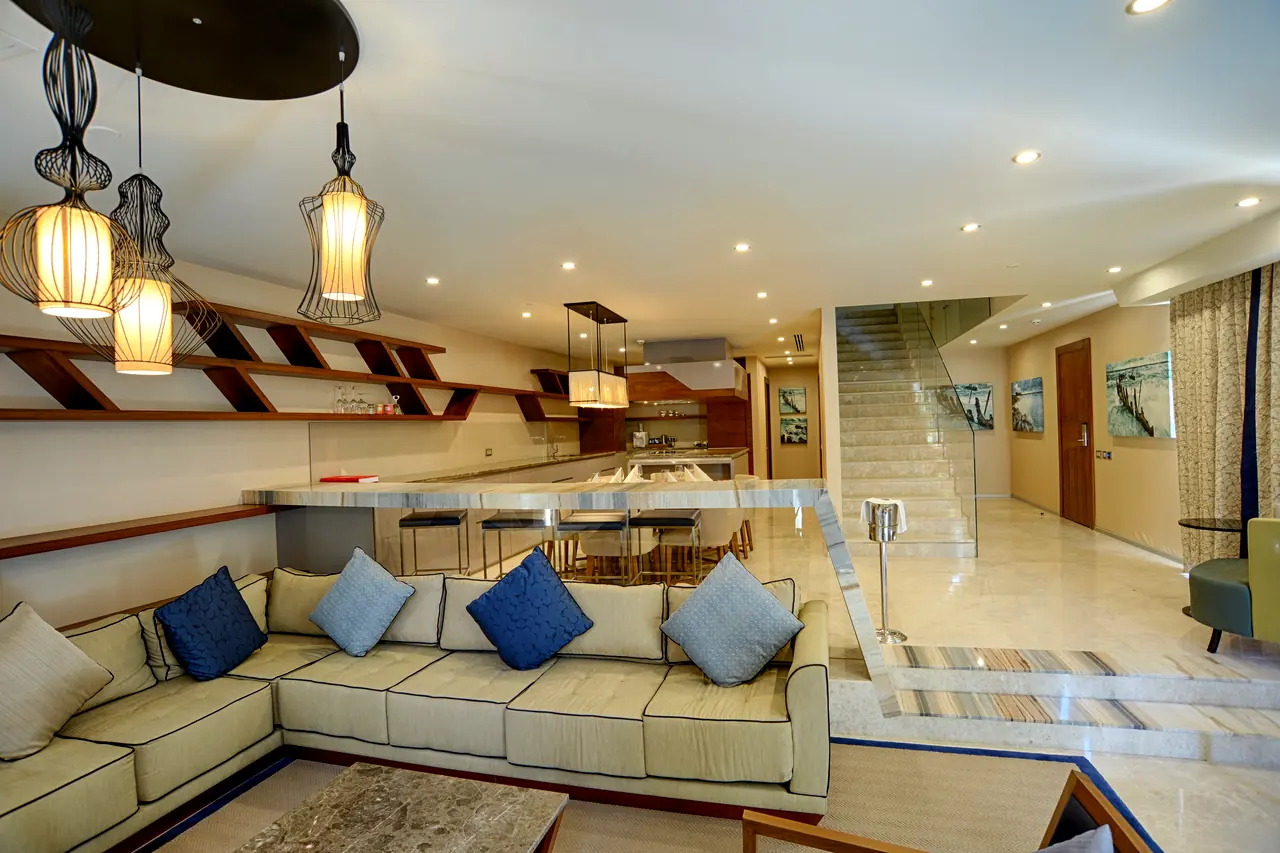Rixos Premium Belek — Suite lounge with corner sofa and lantern pendants